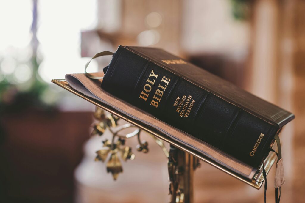 pexels-photo-372326-372326 Holy Bible open on a stand inside a church, symbolizing faith and spirituality.
